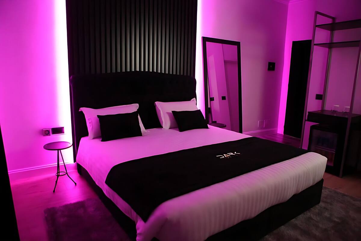 Ein modernes Schlafzimmer mit einem großen Bett, einem Nachttisch und einem Kleiderschrank.