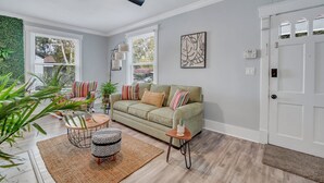 Una sala de estar con sofá, sillones, una mesa de centro y un ventilador de techo.