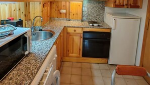 A kitchen with wooden cabinets, a granite countertop, a sink, a dishwasher, and a microwave. - North facing apartment - Falcó 12 (Pla de l'Ermita)