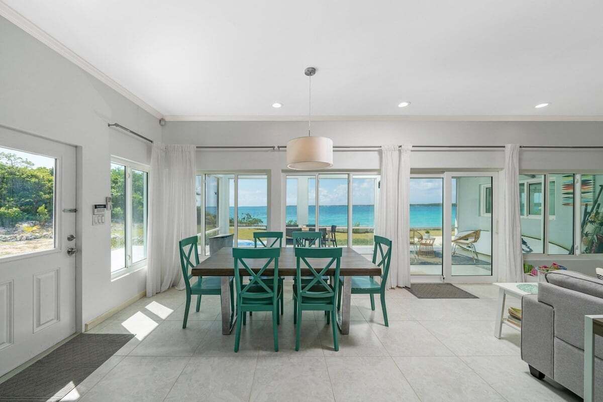 A spacious dining area with a view of the ocean, a modern kitchen, and a balcony with a view.