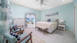 Une chambre à coucher comprenant un lit, un bureau, une chaise, une commode et un ventilateur de plafond.