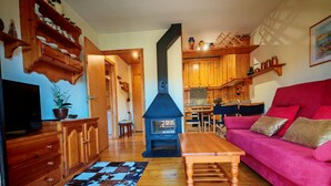 Un salon chaleureux avec une cheminée, des meubles en bois et un canapé rouge.