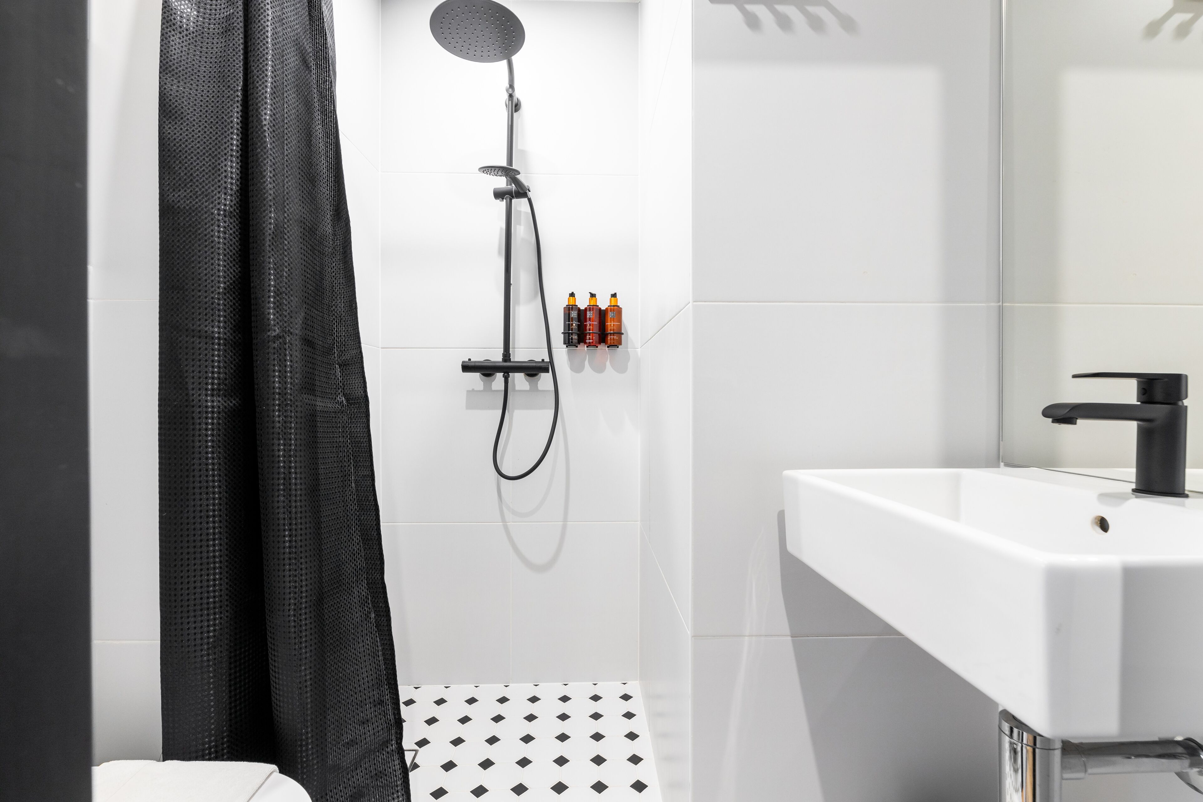 Un baño moderno con ducha, lavamanos e inodoro.