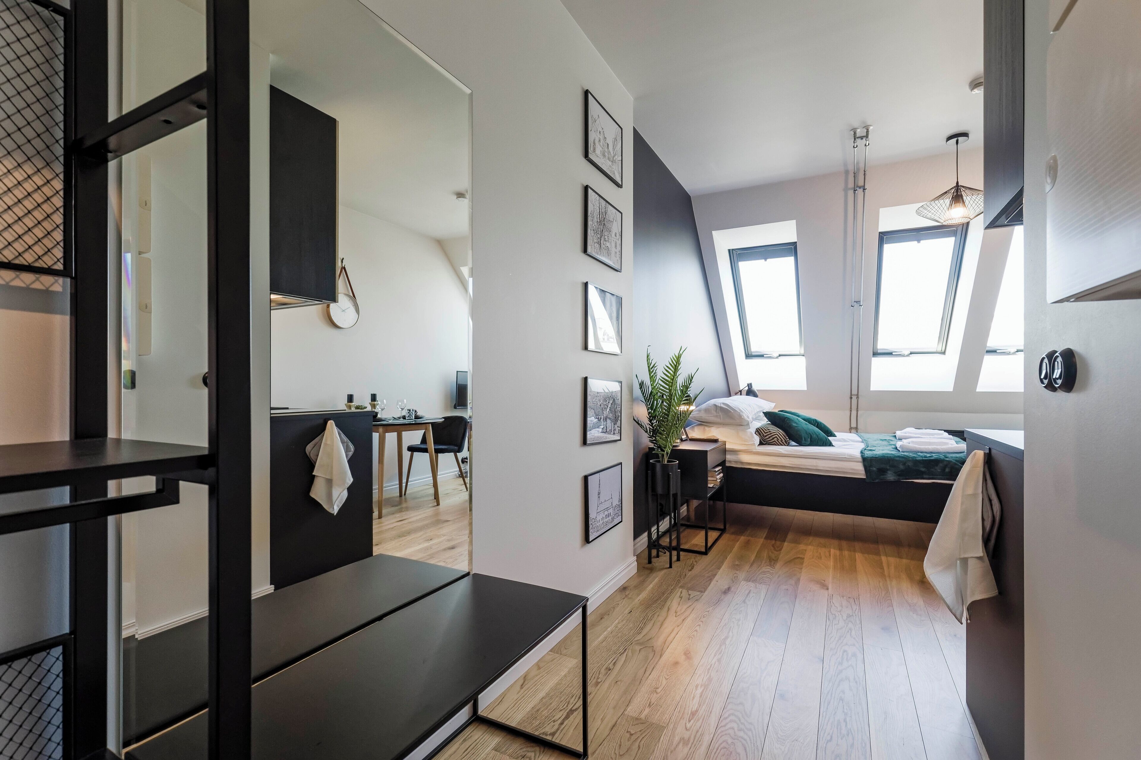 A modern, compact living space with a bed, a desk, and a dining area.