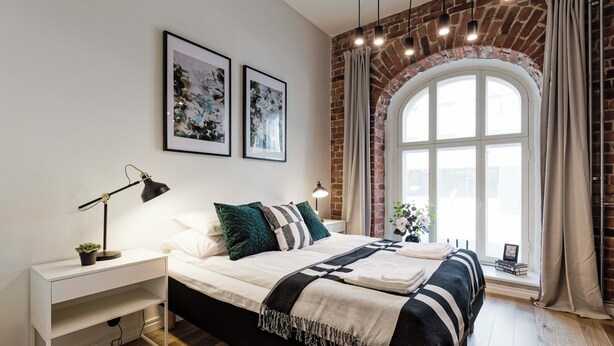A modern bedroom with a large bed, a nightstand, a desk, and a window with curtains. - Bob W Tallinn City Centre - Avangard  (Tallinn)