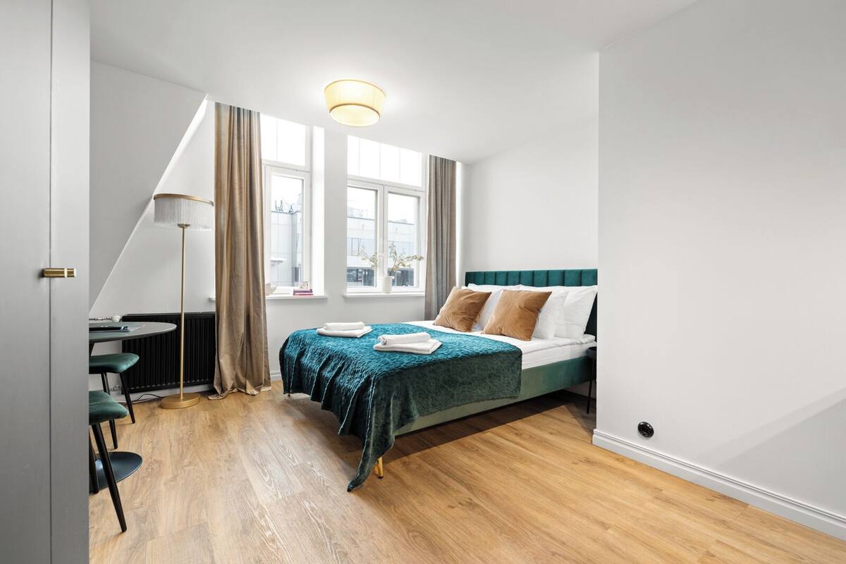 A modern bedroom with a bed, a desk, and a chair.