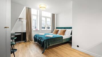 A modern bedroom with a bed, a desk, and a chair.