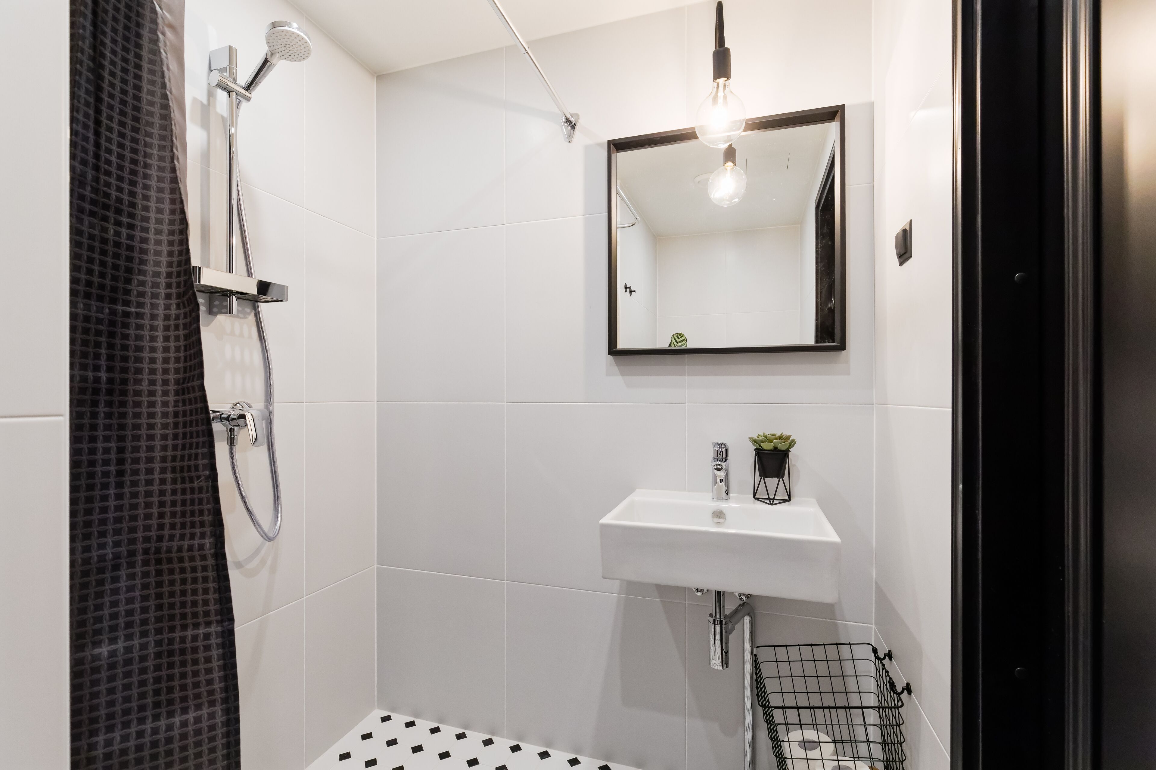 Ein modernes Badezimmer mit Dusche, Waschbecken und Spiegel.
