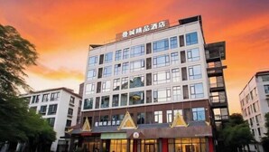 A multi-story hotel with a modern design, featuring a prominent entrance with a golden awning and a sign indicating it is a hotel. - Mancheng Boutique Hotel (Mengla)