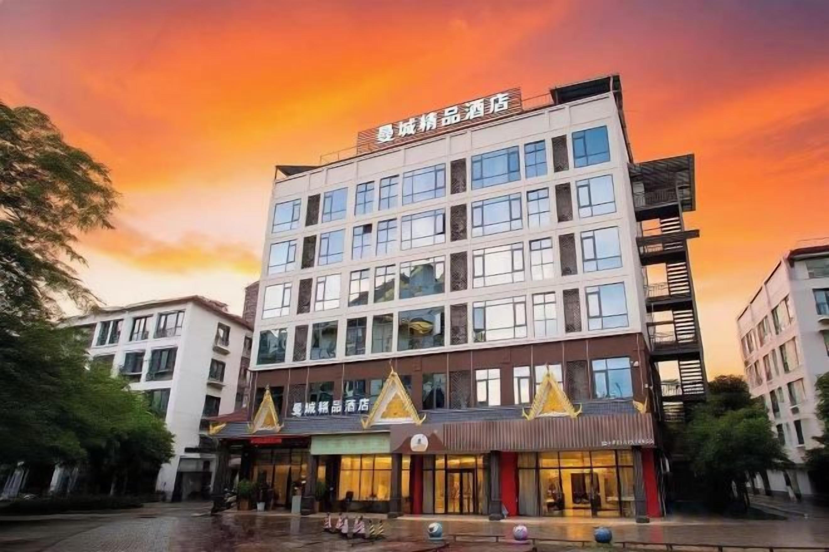 A multi-story hotel with a modern architectural design, featuring a prominent entrance with a sign and a series of windows on the facade.