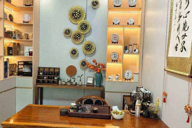 A dining area with a wooden table, decorative wall art, and shelves with various items.