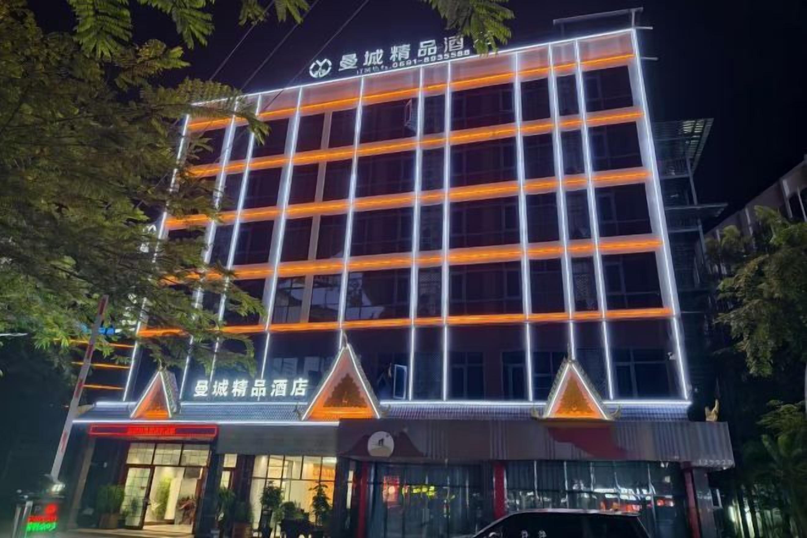 A multi-story hotel with a modern facade, illuminated signage, and a prominent entrance.