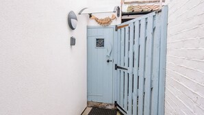A light blue door with a metal latch, a small window, and a decorative fish on the wall above it. - The Fish Store, Aldeburgh (Aldeburgh)