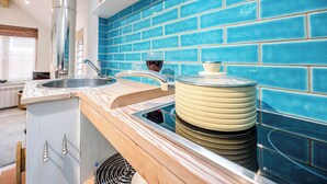 A modern kitchen with a blue tiled backsplash, stainless steel sink, and wooden countertop. - The Fish Store, Aldeburgh (Aldeburgh)