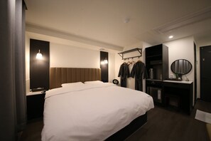 A modern hotel room with a large bed, bedside table, and a built-in wardrobe. - 25 HOTEL (Uiwang)