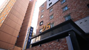 Un hôtel à la façade en briques, sur laquelle on peut voir une enseigne indiquant le numéro 25.