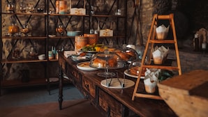 A rustic kitchen with wooden shelves, a stone wall, and a variety of food items and kitchenware. - Castello di Rocca Cilento (Lustra)