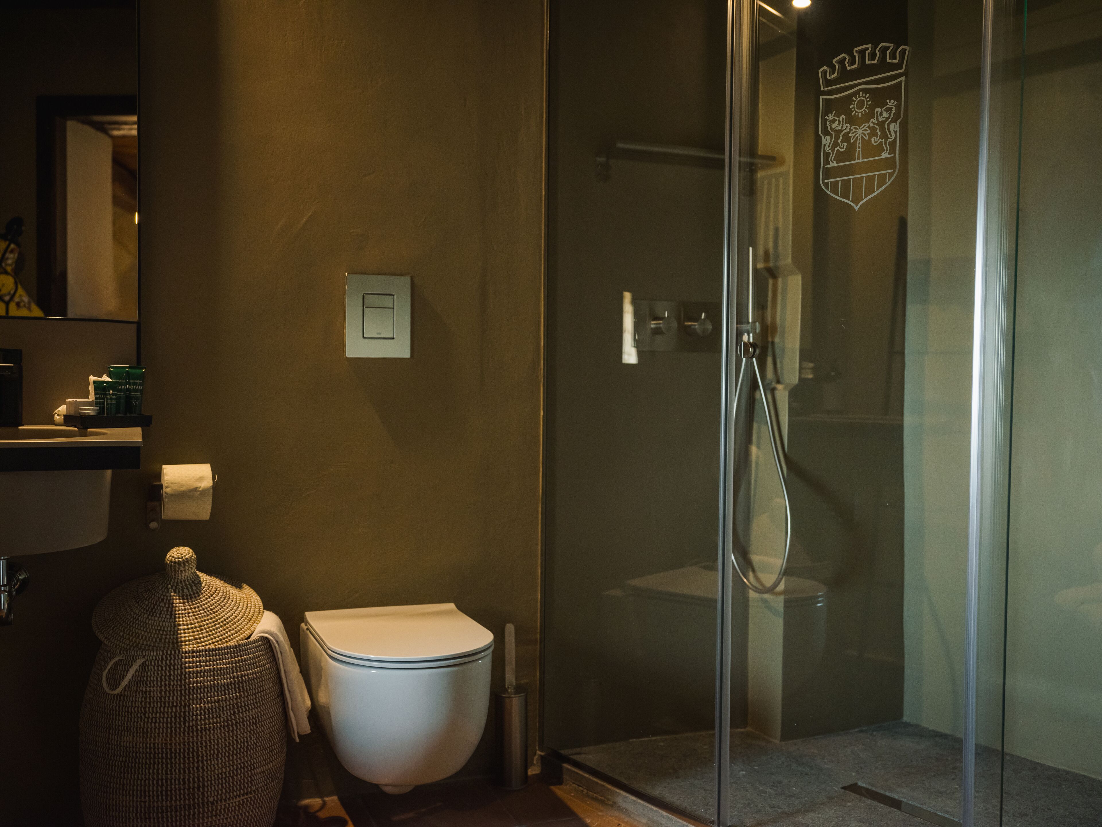 A bathroom with a glass-enclosed shower, a white toilet, and a towel rack.