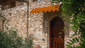 A stone building with a wooden door and a metal railing. - Castello di Rocca Cilento (Lustra)