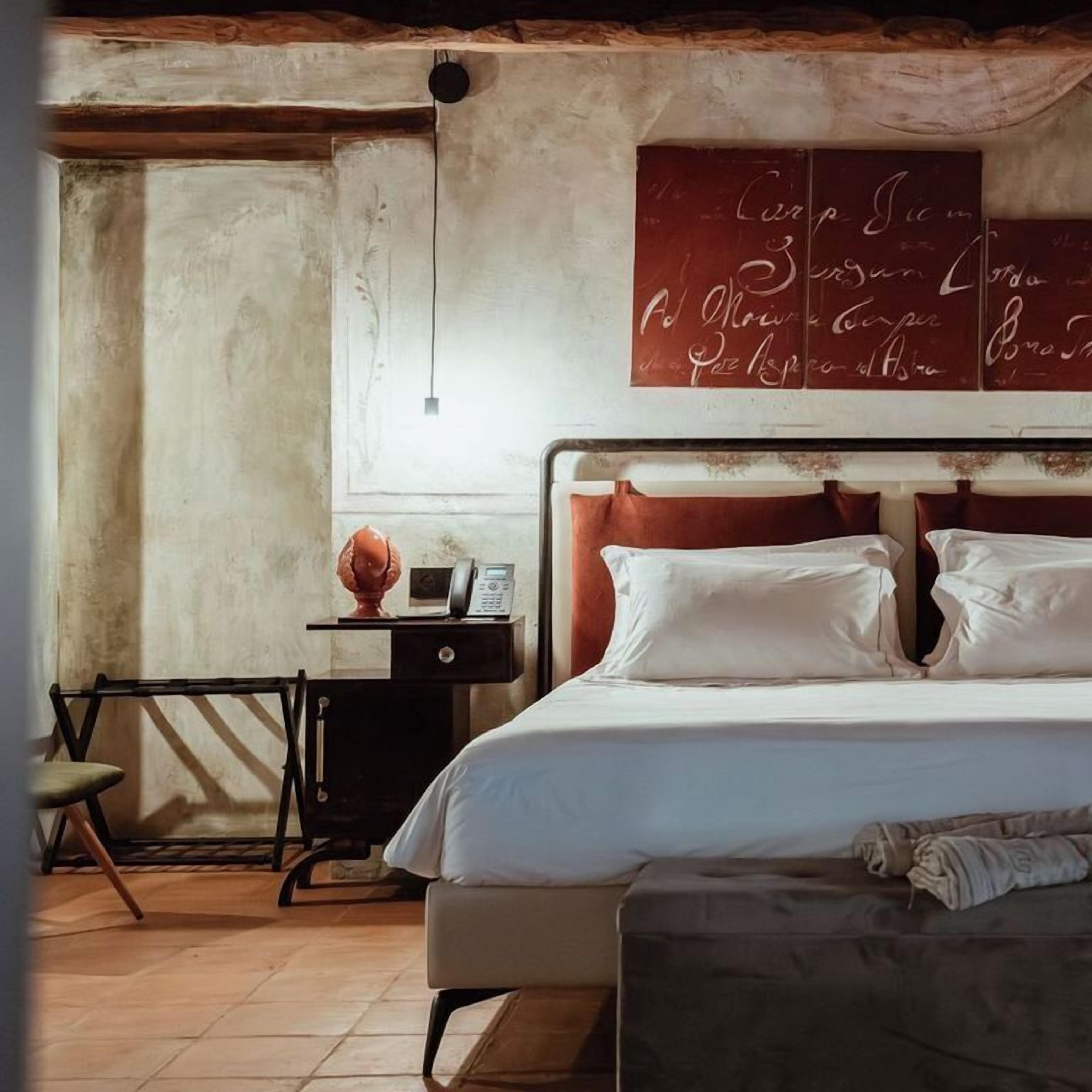 A bedroom with a bed, bedside table, and a wall with a red sign.