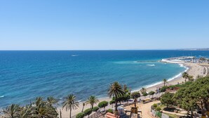 A coastal view with a beach, palm trees, and a clear sky. - Apartment with Shared Pool, Sea View, Wi-Fi and Air Conditioning (Marbella)