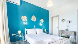 Une chambre à coucher comprenant un lit, des tables de chevet, une commode et des miroirs décoratifs fixés au mur.