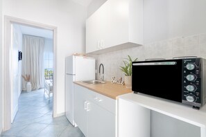 Een koelkast, een oven, een kookplaat, een koffiezetapparaat/waterkoker