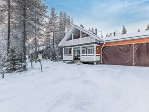 A two-story cabin with a balcony, surrounded by snow-covered trees. - Vacation home Arha by Interhome (Äkäslompolo)
