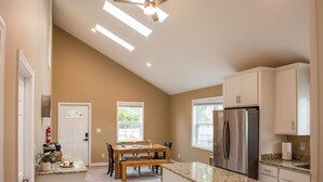 A kitchen with a dining table, built-in appliances, and a ceiling fan.
