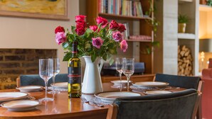 Une table à manger dressée avec des assiettes, des verres et une bouteille de vin.