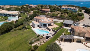 Une propriété située sur la côte, dotée d’une grande piscine, de plusieurs villas et offrant une vue sur la mer.