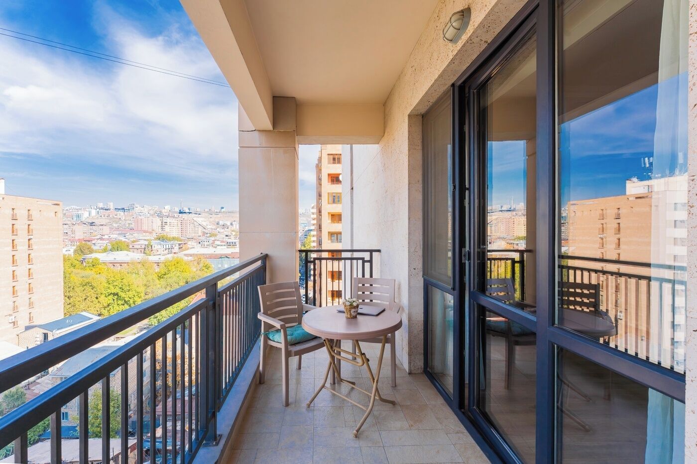 Ein Balkon mit Tisch und Stühlen und Blick auf die Stadt.