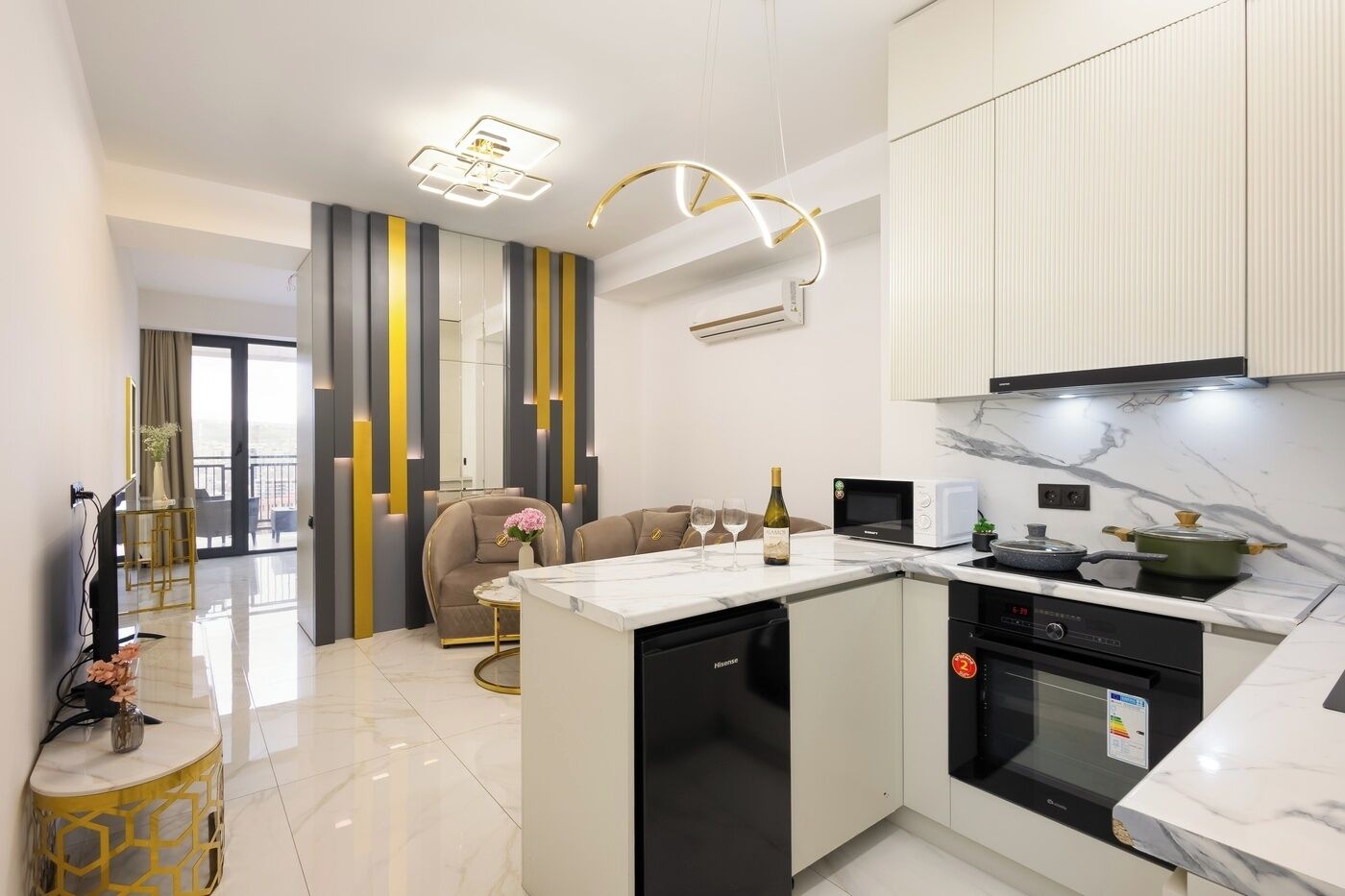 A modern kitchen with a central island, built-in appliances, and a dining area with a sofa and chairs.