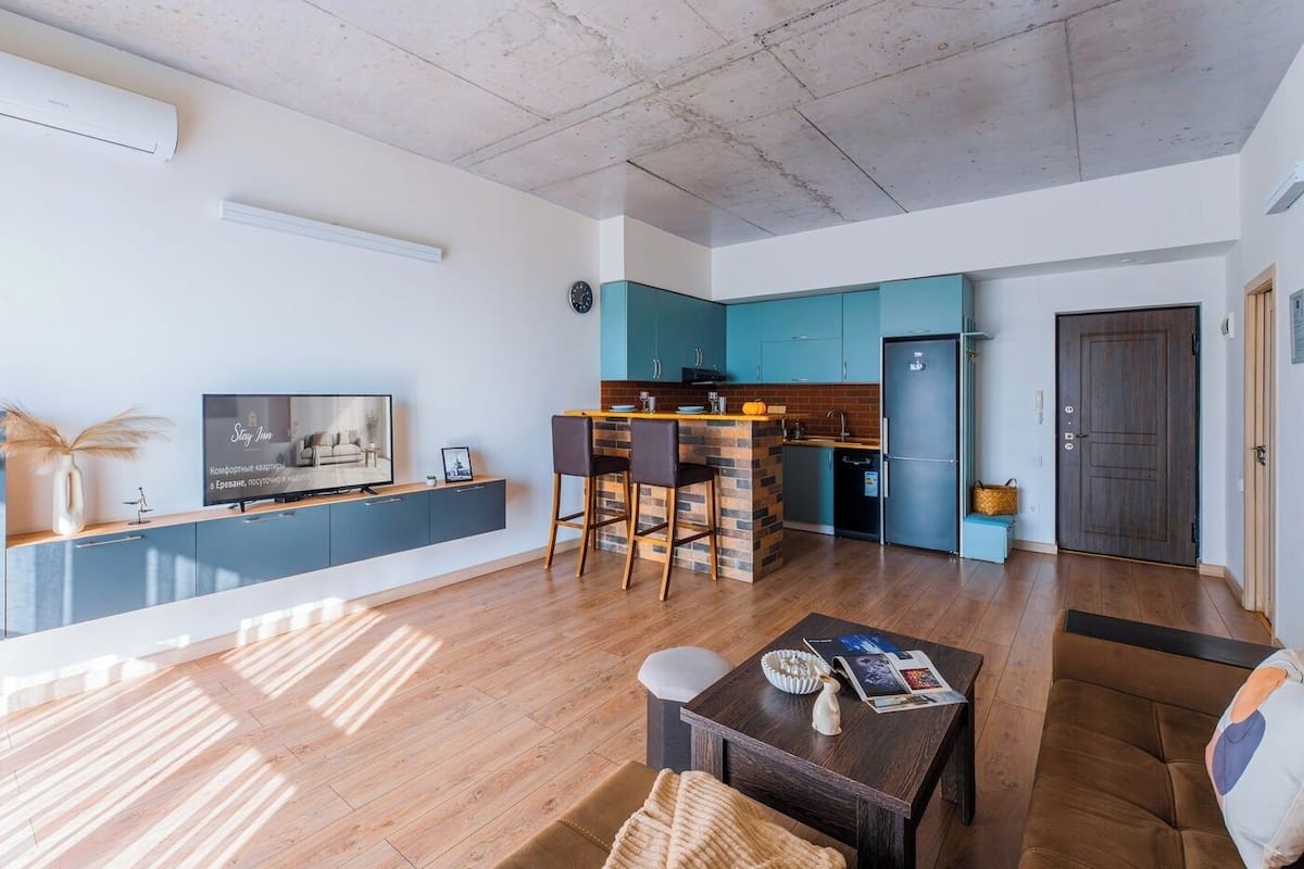 A modern apartment with a kitchen, dining area, and living room.