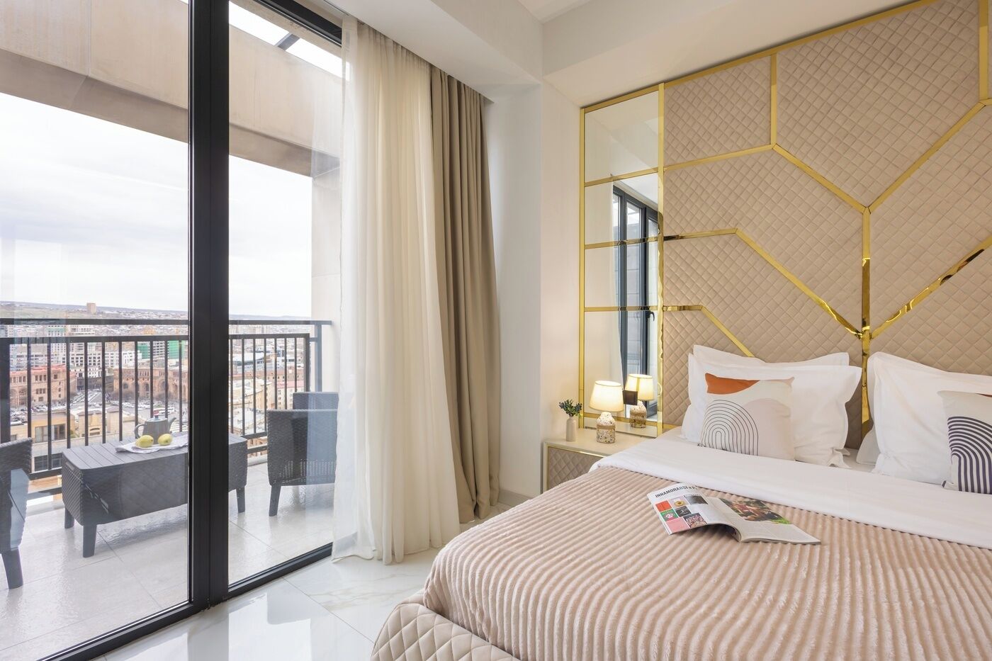 Una camera d'albergo con un letto grande, un balcone vista e un arredamento moderno.