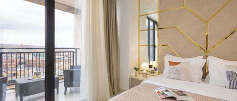 Una camera d'albergo con un letto grande, un balcone vista e un arredamento moderno.