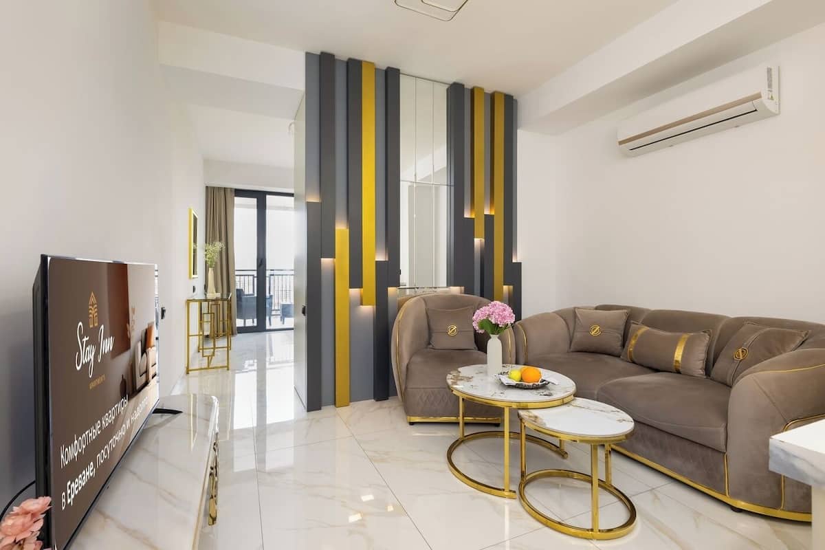 A modern living room with a sofa, a coffee table, and a TV.