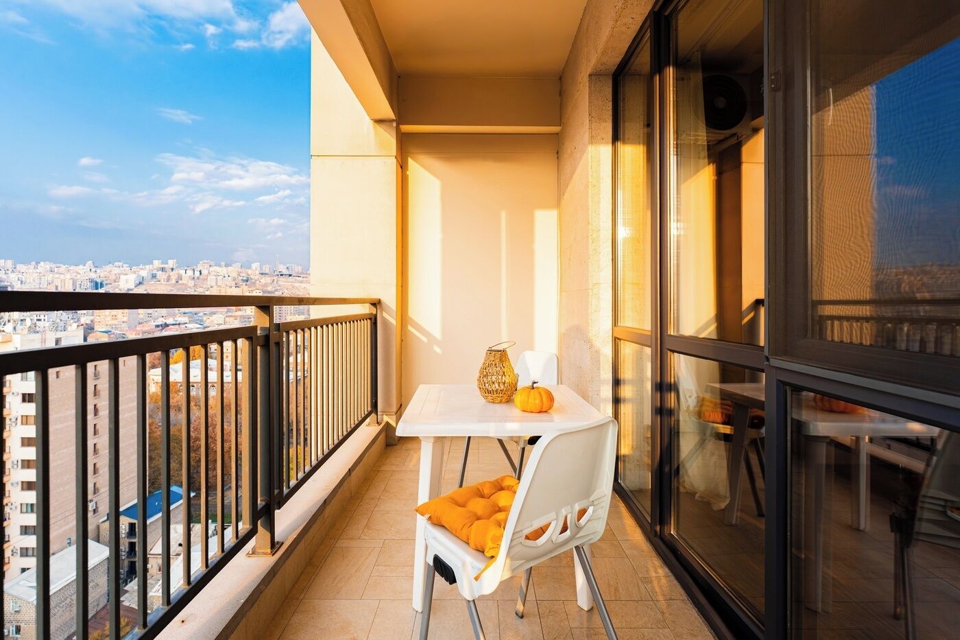 A balcony with a table, chair, and decorative items.
