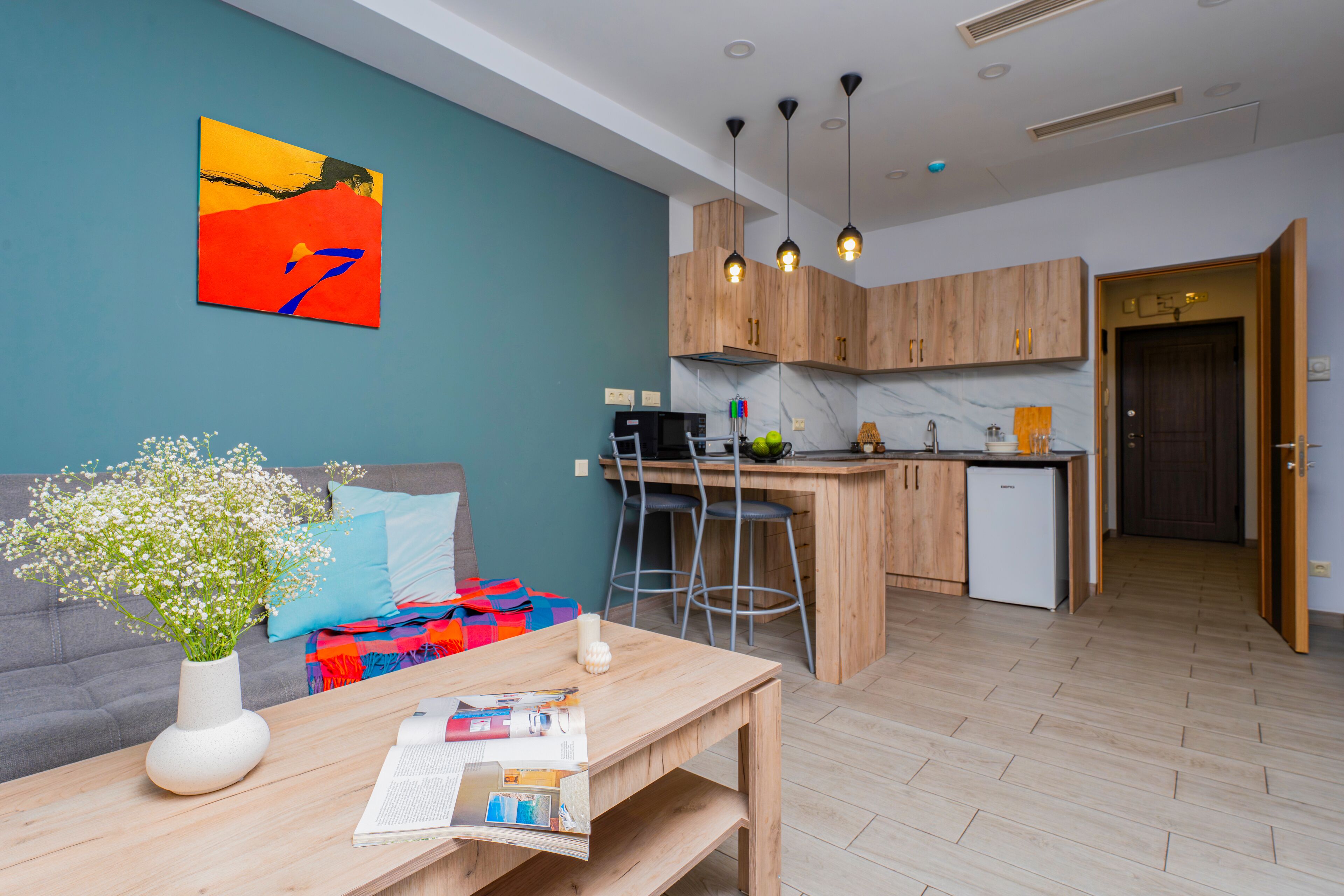 A modern apartment with a kitchen, dining area, and living room.