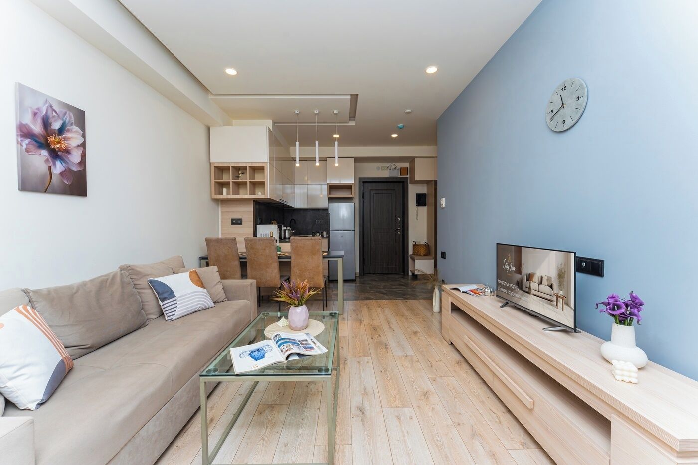 A modern living room with a glass coffee table, a sofa, and a TV stand.