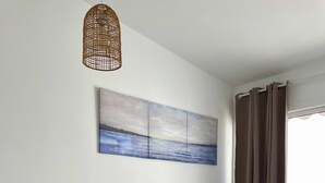 A modern living room with a grey sofa, white chairs, a wooden table, a wall-mounted painting, and a large window with curtains. - Relaxing Ocean Views, Closed to the Beach (San Bartolomé de Tirajana)