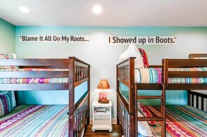 A room with bunk beds, a small table with a lamp, and two motivational posters on the wall. - Nashville rooftop deck & game room house, sleeps 10 near broadway (Nashville)