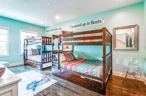 Une chambre avec des lits superposés et une affiche sur le mur indiquant : « Je me suis retrouvé(e) enseveli(e) sous la neige, les bottes aux pieds. »