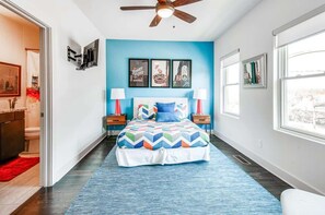 A bedroom with a bed, a ceiling fan, a TV, and framed pictures on the wall. - Nashville game room & bar house, sleeps 10, 3BR near Parthenon (Nashville)