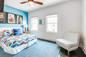 A bedroom with a bed, a chair, a ceiling fan, and framed pictures on the wall. - Nashville group house with game room, full bar & themed bedrooms, sleeps 10 (Nashville)