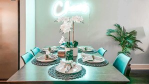 A dining table set with plates, napkins, and a centerpiece of white flowers. - Music-themed Nashville home with game room, bar & bunk rooms, sleeps 10 (Nashville)