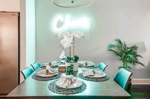 A dining table set with plates, napkins, and a centerpiece of white flowers. - Nashville game room & bar house, sleeps 10, 3BR near Parthenon (Nashville)