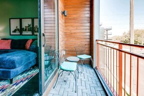 A balcony with a wooden wall, a sofa, two chairs, and a small table. - Nashville rooftop deck & game room house, sleeps 10 near broadway (Nashville)