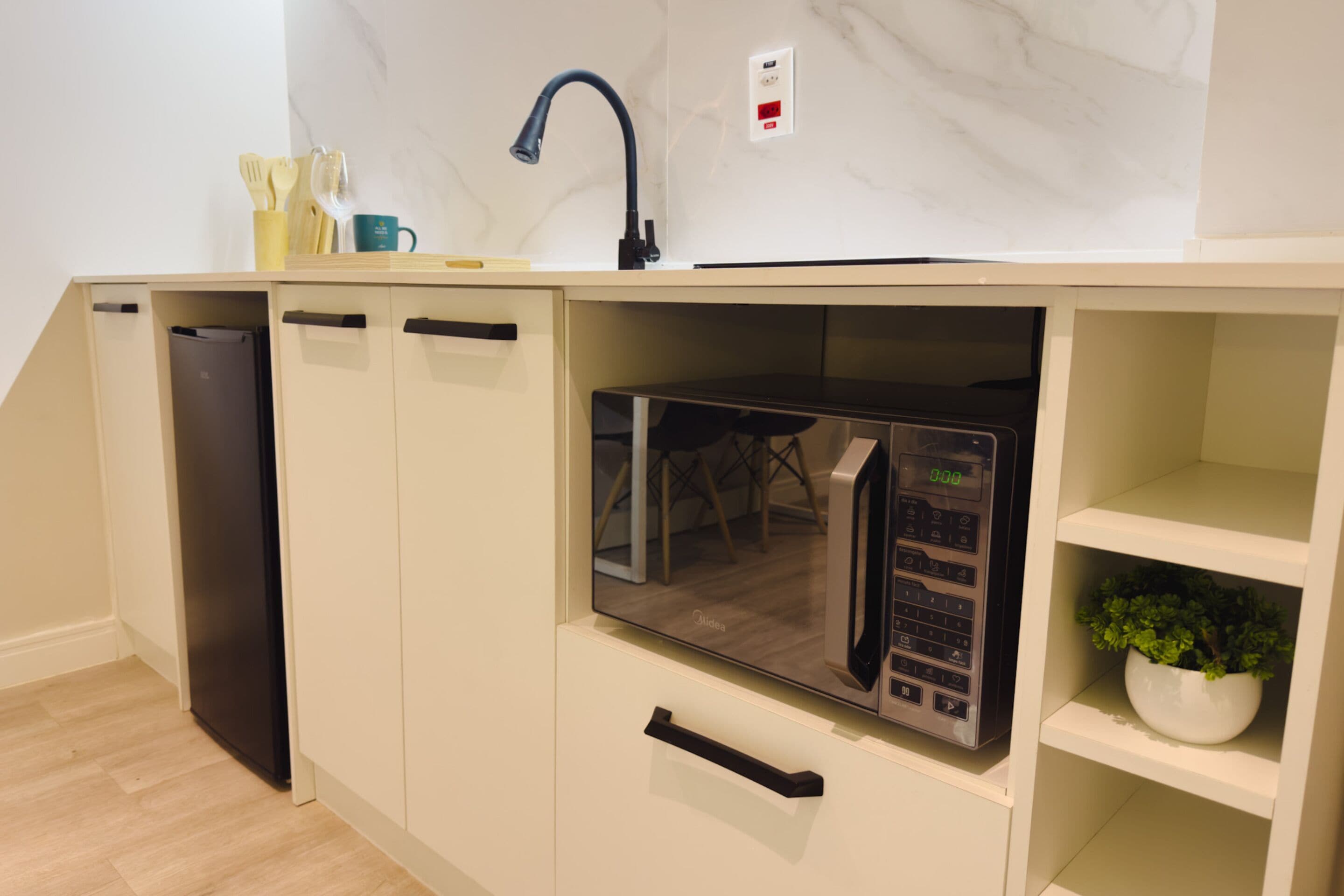 A kitchen with a built-in microwave, a sink, and a cabinet.