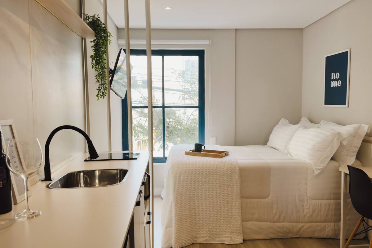Une chambre moderne avec un lit, une table de chevet et une fenêtre donnant sur un beau paysage.